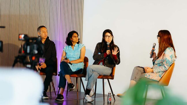 4 people sitting on stage, 3 women and 1 man